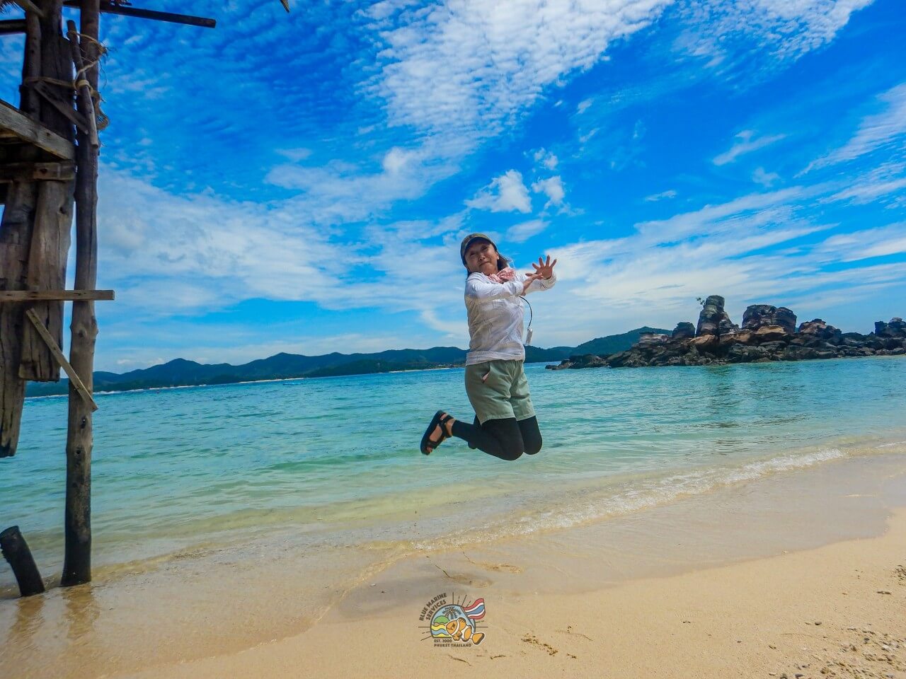 カイ島の白砂ビーチでジャンプするお客様