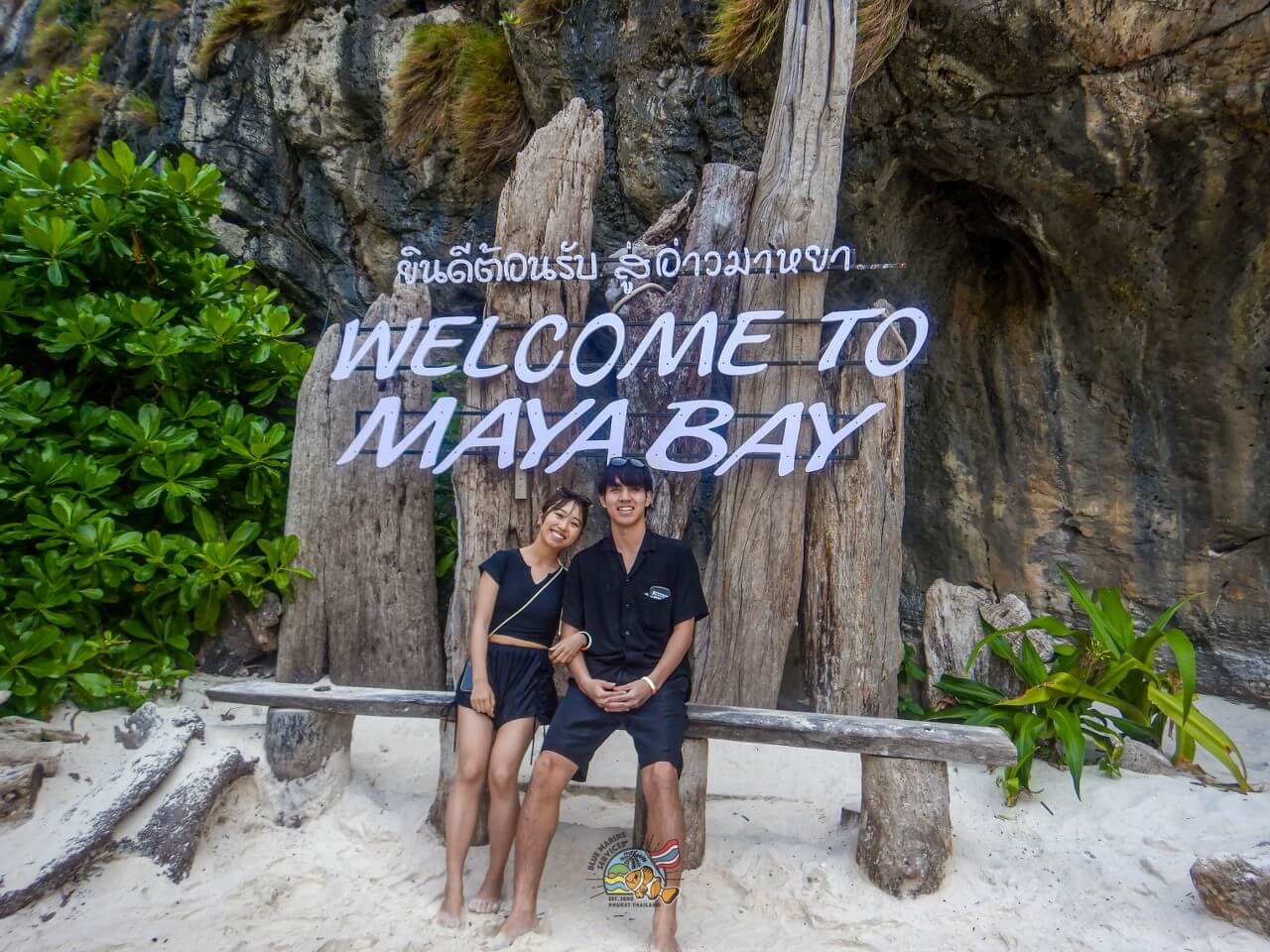 マヤベイのWELCOME TO MAYA BAY看板前に座る2名のお客様