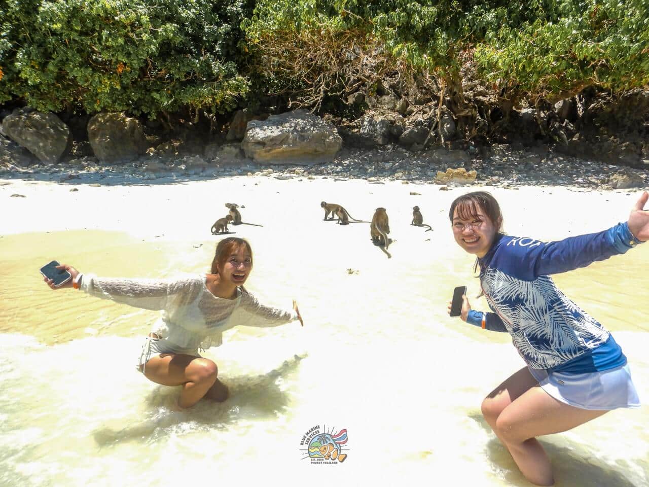 モンキービーチの砂浜で野生のサルと撮影する2名のお客様