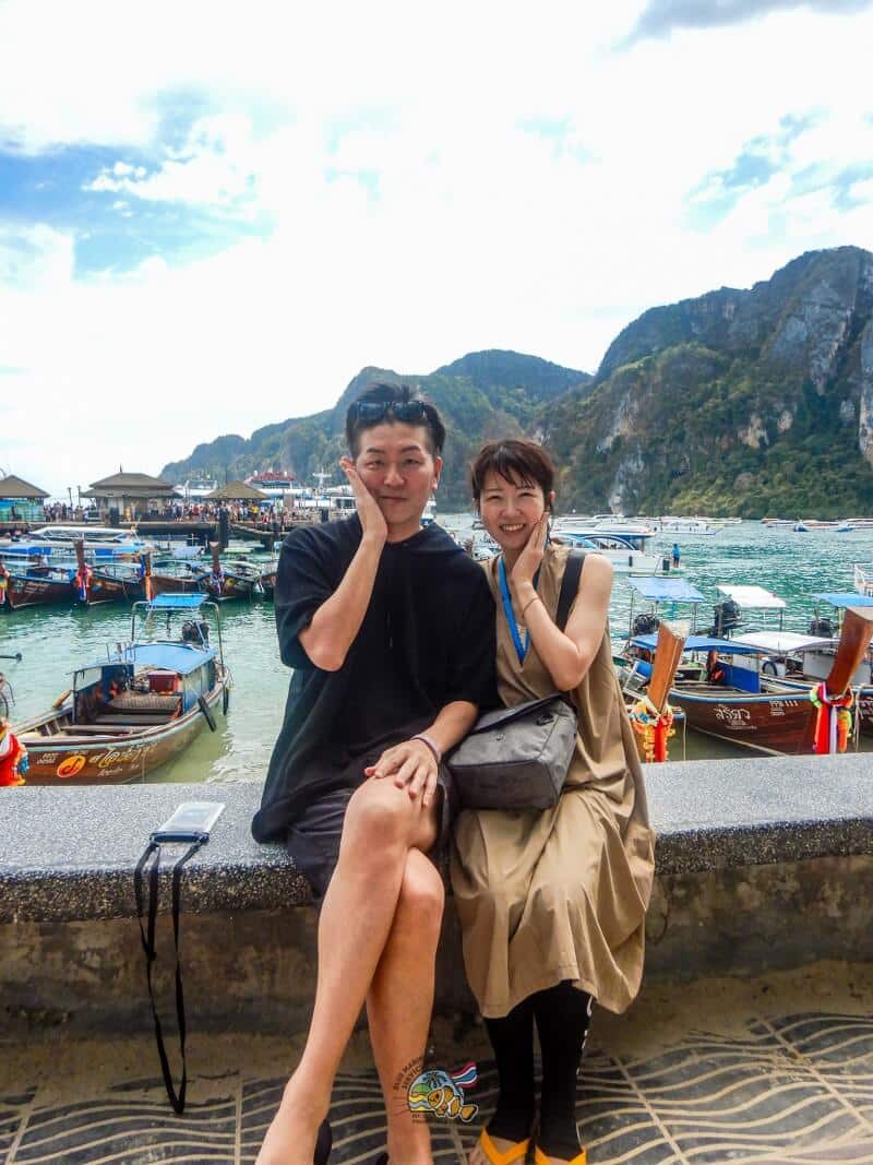 ピピ島のロングテールボートを背景に撮影する2名のお客様