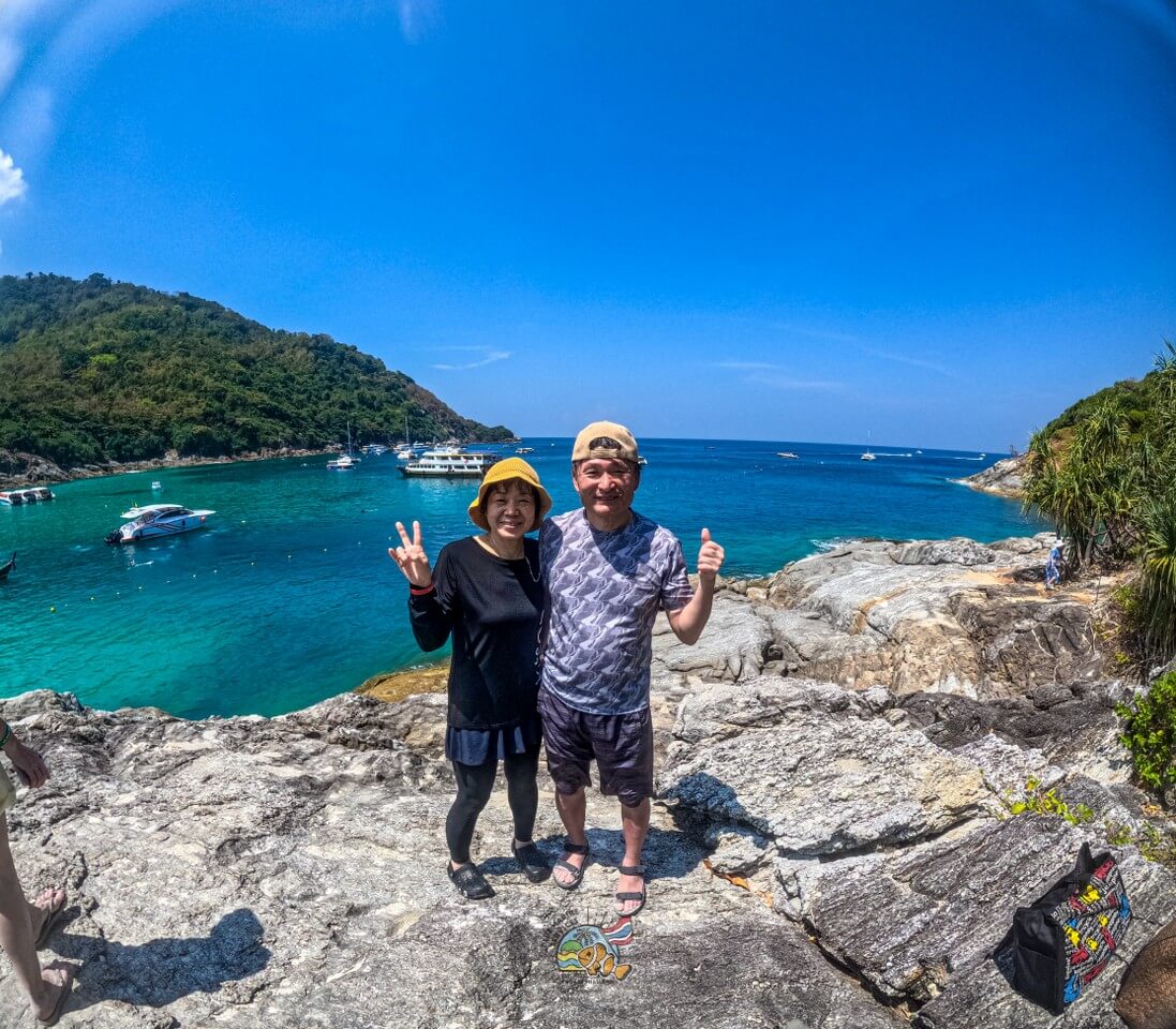 ラチャヤイ島の海を背景に岩場のビューポイントで撮影する2名のお客様